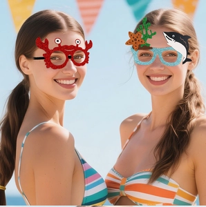 Kids wearing ocean themed party glasses featuring shark and crab designs on a sunny beach