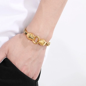 Detailed close-up of a bold gold snake head link bracelet worn on a man's wrist