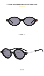 Detail view of oval sunglasses with black frames, light grey lenses and contrast side temples