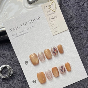 Detail view of handmade amber cat eye press-on nails set with glitter and size chart