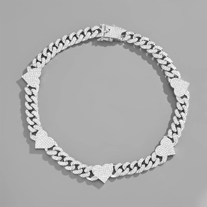 Detail of silver Cuban chain necklace with heart charms and clear crystal pavé setting