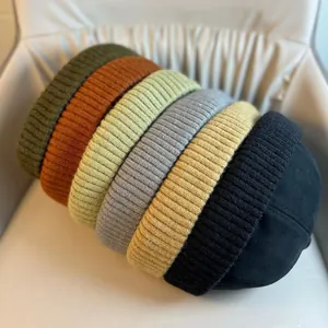 Detailed view of knitted brimless beanies in seven different colors with ribbed texture