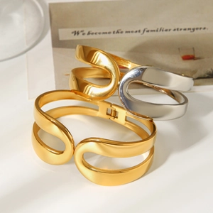 Macro detail of intertwined gold and silver stainless steel bangles with mirror finish