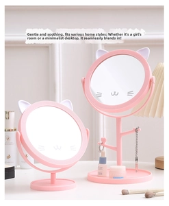 Pink cat-ear desktop vanity mirror with jewelry hooks and storage tray on table