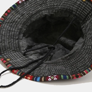 Close-up of washed cotton bucket hat featuring ethnic woven ribbon and windproof cord