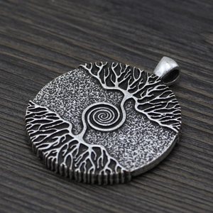 Close-up of vintage silver Norse Tree of Life pendant with embossed spiral tree details