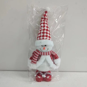 Detail of a plush Christmas snowman doll with checkered hat and striped scarf in packaging