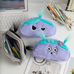 Detailed close-up of fluffy cartoon monster pencil cases with embroidery and hair clips