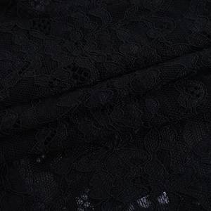 Macro view of black lace fabric showing intricate floral hollow out patterns and texture