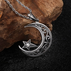 Vue macro du pendentif lune et étoile en argent avec motif creux et petit diamant