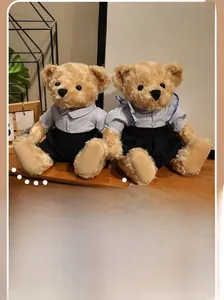 Detailed view of two light brown plush teddy bears in blue and white school uniforms