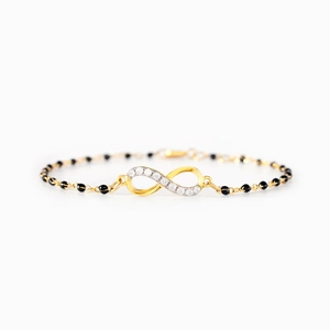 Gold infinity bracelet with white stones and black beads on a sleek minimalist chain