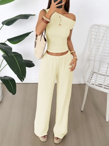 Detail of the light yellow two-piece set featuring pleated texture and one-shoulder top