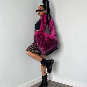 Detail of pink faux fur heart-shaped tote bag worn in a trendy y2k style with model