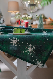 Détail de nappe de Noël verte montrant la texture tissée épaisse et le motif de flocon de neige