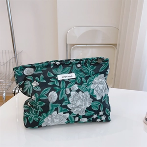 Macro detail of retro jacquard fabric makeup bag featuring green floral woven texture