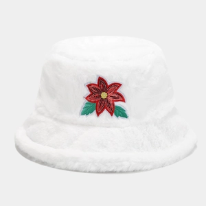 Dettaglio di un cappello a secchiello in peluche bianco con fiore di Natale ricamato