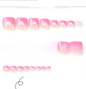 Détails des faux ongles dégradés roses avec motifs de cœurs blancs et tailles variées