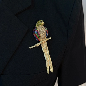 Elegant parrot brooch with colorful enamel and crystals pinned on a black suit lapel