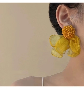 Macro shot of yellow beaded flower tassel earrings with translucent fabric petals