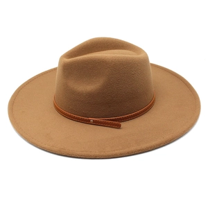 Macro shot of brown felt fedora hat featuring a leather band with metal rivet details