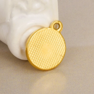 Detailed macro view of a 18K gold-plated stainless steel round pendant with dotted texture