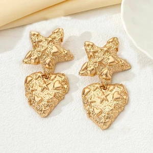 Irregular golden star and heart dangle earrings with embossed relief on white silk background
