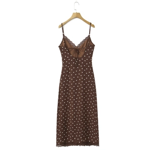 Détail de robe marron à pois avec dentelle et dos nu lacé sur cintre en bois
