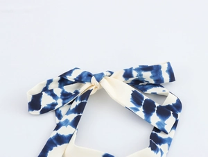 Detail of blue and white tie-dye fabric featuring a bow-tie halter neck strap