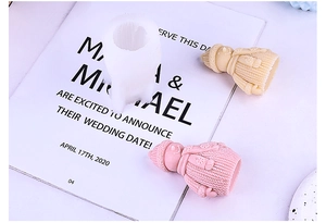 Close-up of silicone mold and girl figurines showing intricate knitted sweater texture detail