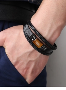 Close-up of multilayer men's leather bracelet featuring a polished tiger eye stone bead