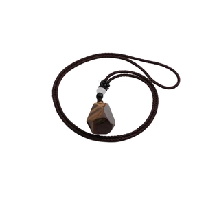 Macro shot of irregular tiger eye stone perfume bottle pendant with woven necklace