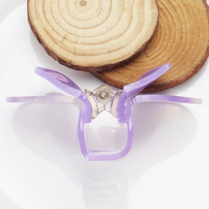 Close-up of a purple butterfly hair claw clip made of acetic acid on a decorative tray