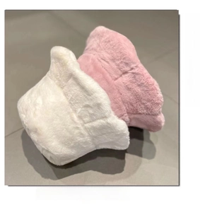Detail of plush faux rabbit fur bucket hats in white and pink for winter warmth