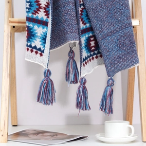 Close-up of ethnic geometric pattern knit shawl with decorative fringe tassels