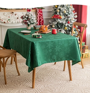 Detail of green Christmas tablecloth with snowflake texture in festive home setting