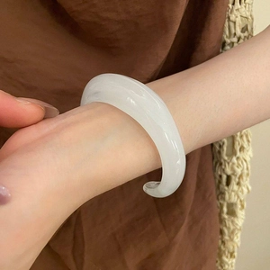 Detail eines minimalistischen, weißen, durchscheinenden Acryl-Armreifs mit Glanz-Finish
