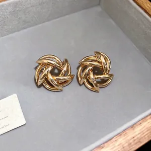 Elegant gold hollow star floral spiral stud earrings on premium velvet background