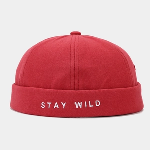 Detailed close-up of red docker cap featuring white STAY WILD embroidery and canvas texture