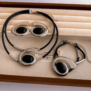 Vintage style jewelry set with oval black stones in silver frames and leather cords