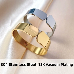 Detail of 304 stainless steel 18K gold plated hinged bangles on white silk fabric