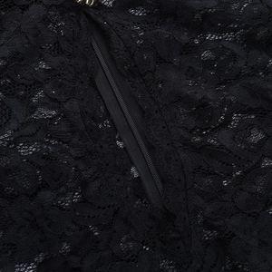 Détail macro de dentelle florale noire et fermeture éclair invisible sur la mini-robe