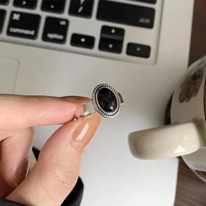 Detail of vintage S925 silver ring with black onyx and twisted rope edge texture