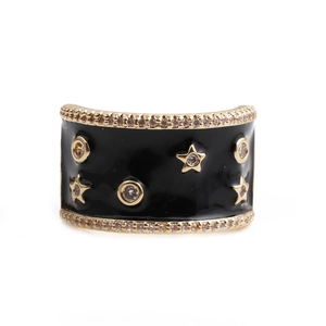 Detail of a wide black enamel band ring with gold stars and sparkling cubic zirconia stones