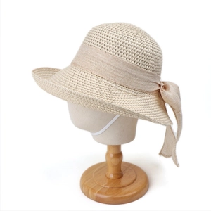 Detail of baby straw hat featuring a bow tie and white elastic adjustable chin strap