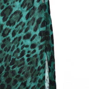 Détail de la fente latérale et de la texture du tissu sur la robe léopard vert et noir