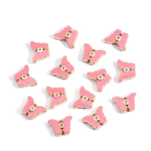 Macro detail of pink butterfly evil eye enamel charms with golden metal edges
