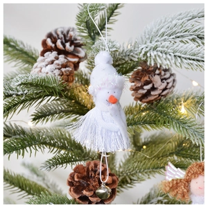 Detail of white plush snowman angel ornament with fringe dress on a Christmas tree