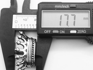Macro shot of a stainless steel crown pendant measured at 17.7 mm with a digital caliper
