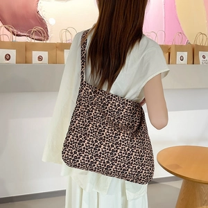 Detailed view of leopard print canvas tote bag carried by model in a minimalist store